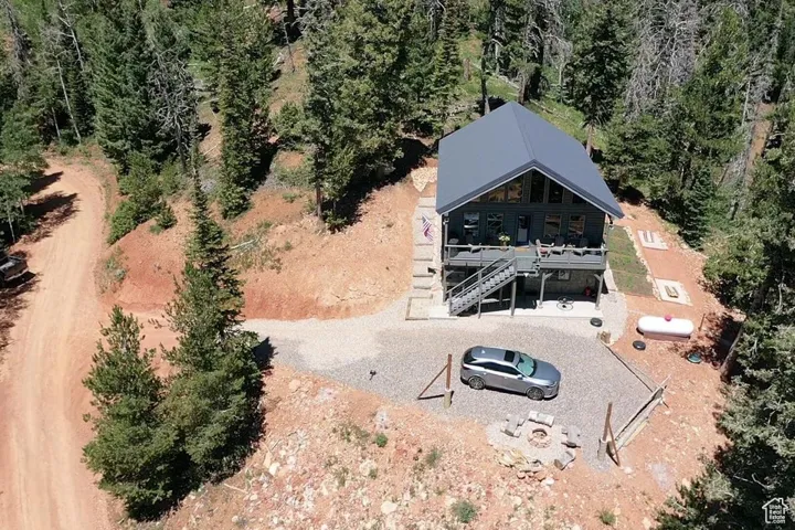 Aerial view of property and surrounding area with a forest