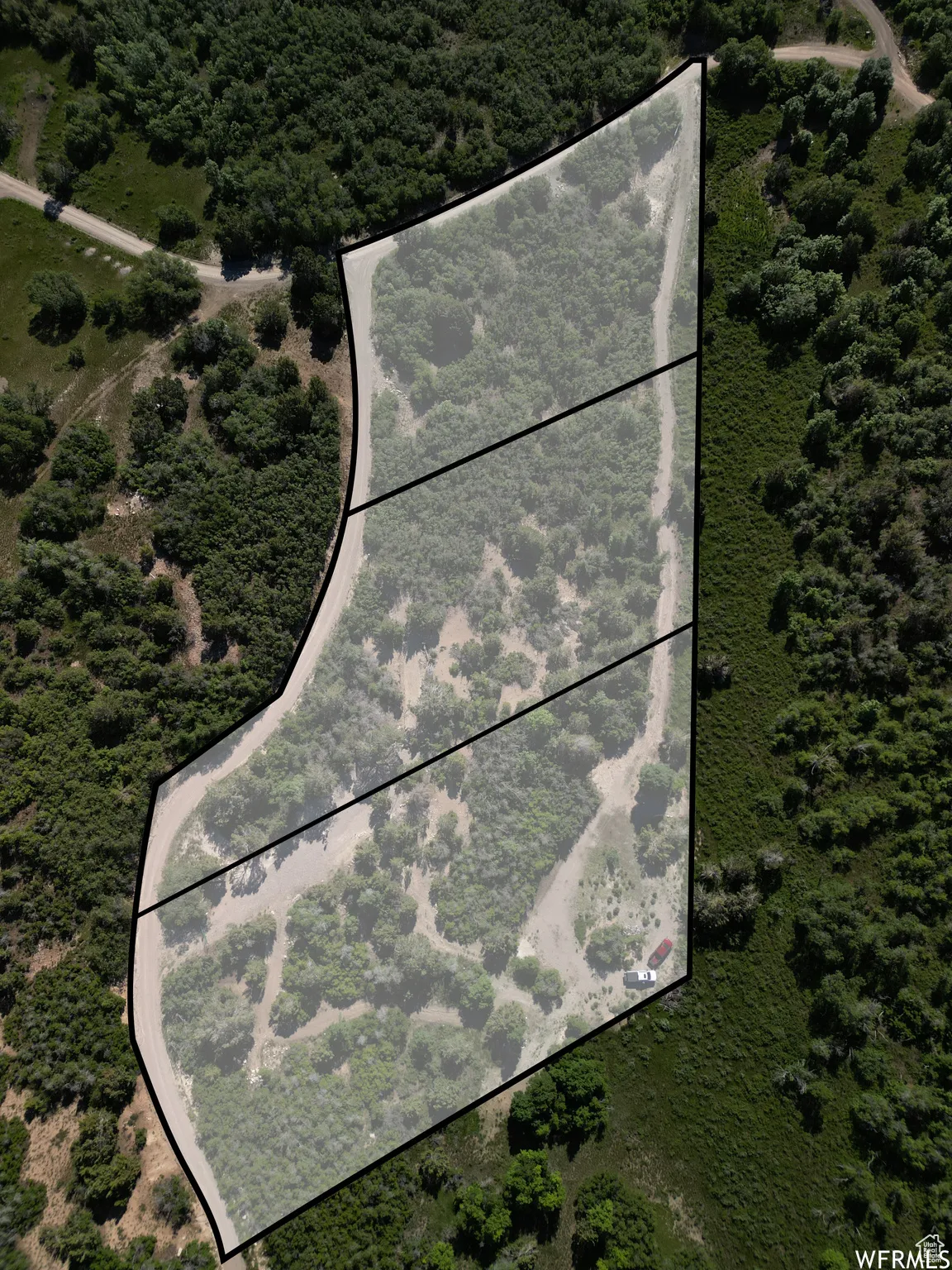 Aerial overview of property's location featuring property parcel outlined and a forest