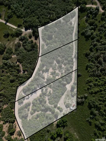 Aerial overview of property's location featuring property parcel outlined and a forest