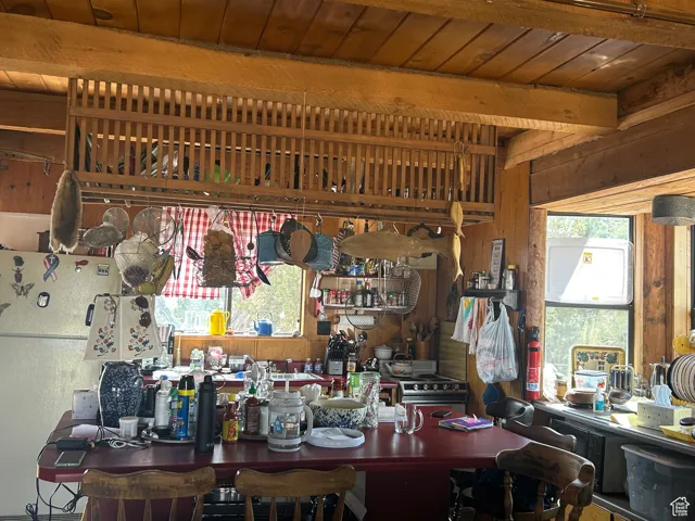 Interior space with a wood ceiling with exposed beams and wood walls