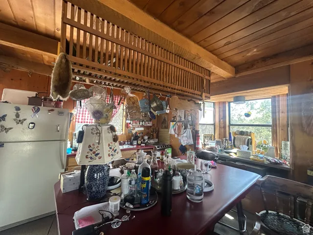 Kitchen with freestanding refrigerator and wooden ceiling