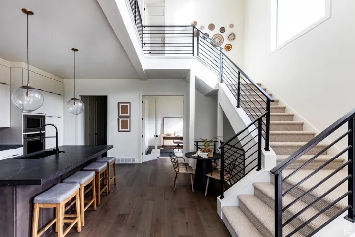 Stairway featuring wood finished floors and a high ceiling