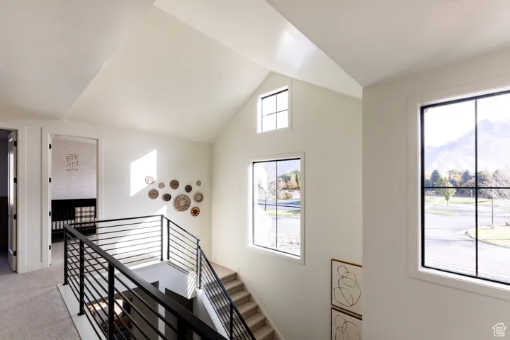 Staircase featuring carpet flooring, lofted ceiling, and a mountain view