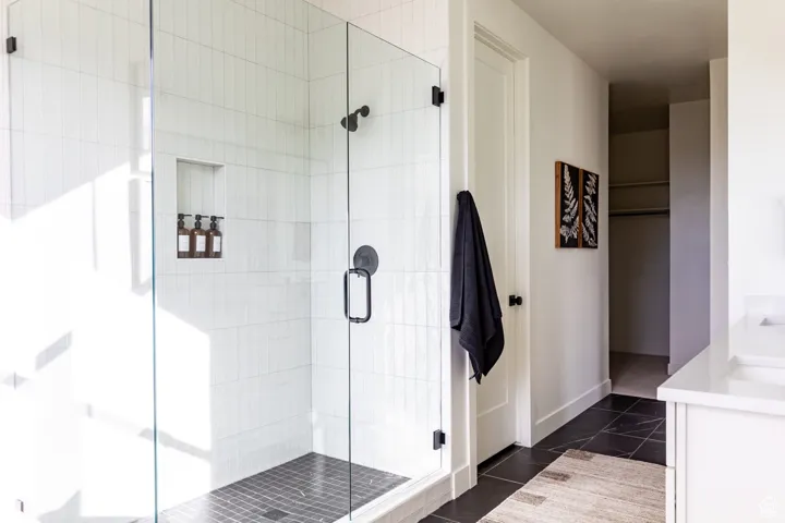 Full bath featuring vanity, a stall shower, and tile patterned flooring