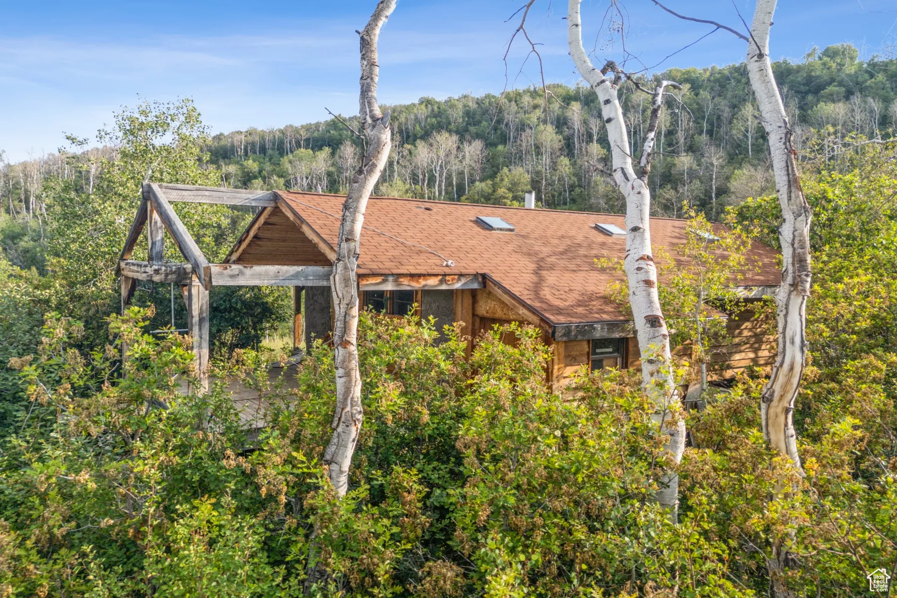 Aerial view of property and surrounding area with a heavily wooded area