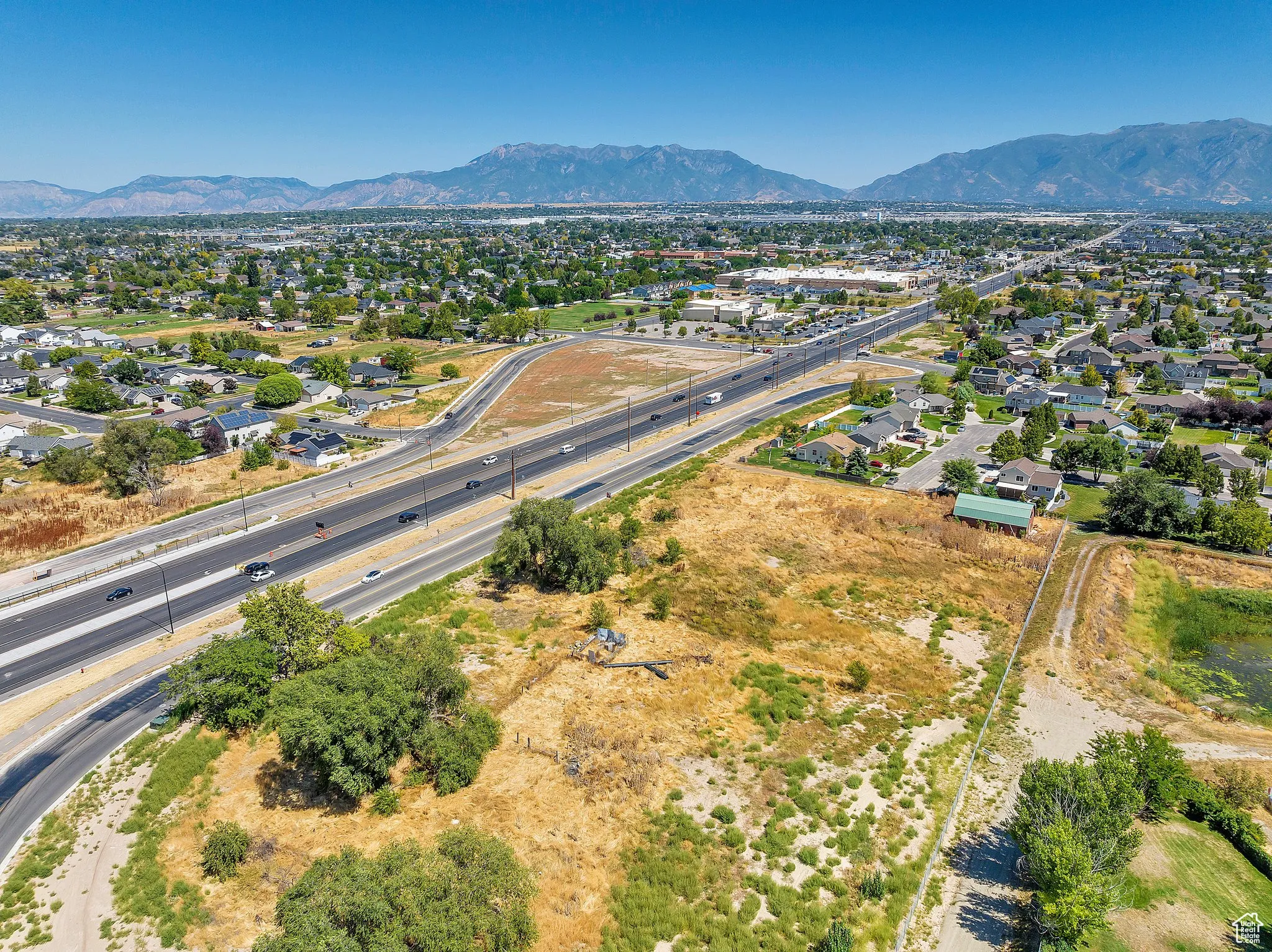 Aerial perspective of suburban area featuring mountains and a main thoroughfare