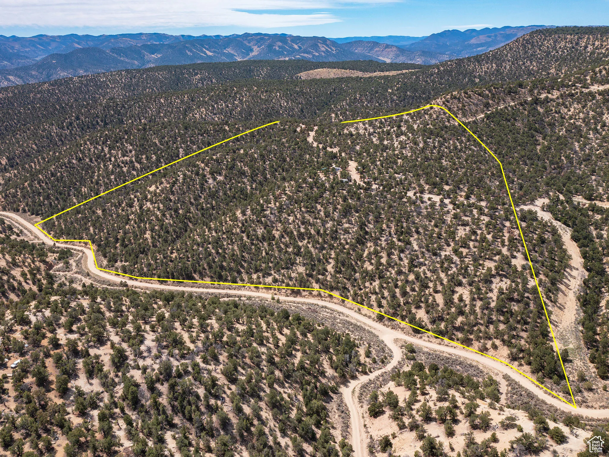 Aerial view of sparsely populated area with a mountain backdrop and property boundaries highlighted