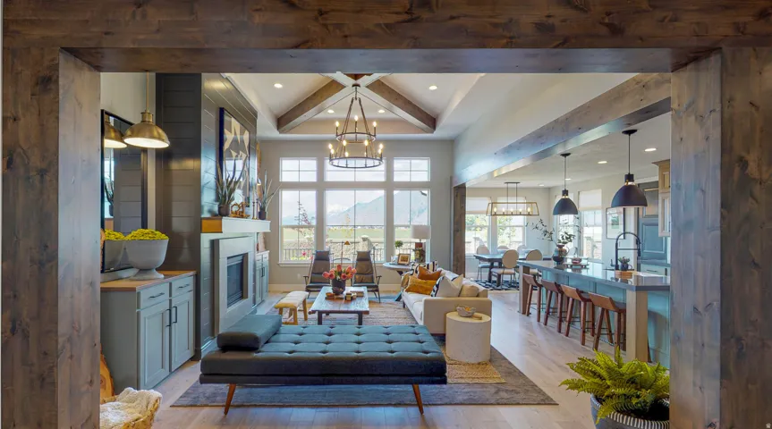 Living room featuring wood finished floors, a glass covered fireplace, beam ceiling, plenty of natural light, and a chandelier