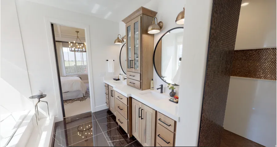 Bathroom featuring ensuite bathroom, dark tile patterned floors, double vanity, and a chandelier