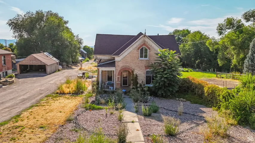View of front of house with brick siding and an outdoor structure