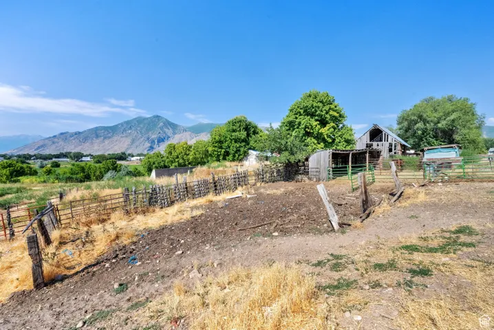 View of yard featuring an outdoor structure, an exterior structure, a view of rural / pastoral area, and a mountain view