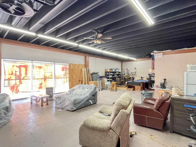 Basement featuring freestanding refrigerator and a ceiling fan