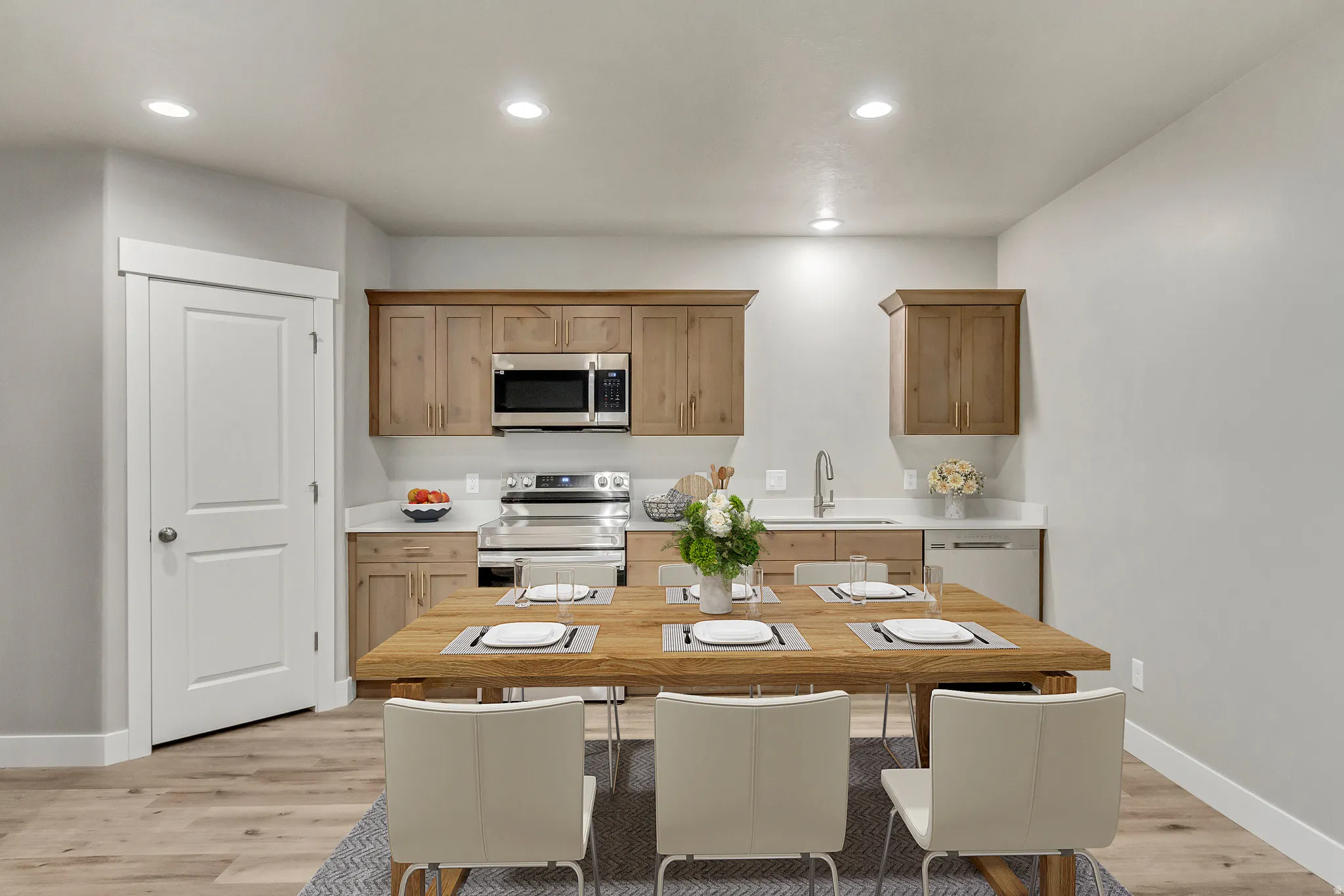 Kitchen with light countertops, stainless steel appliances, light wood-style flooring, recessed lighting, and brown cabinetry
