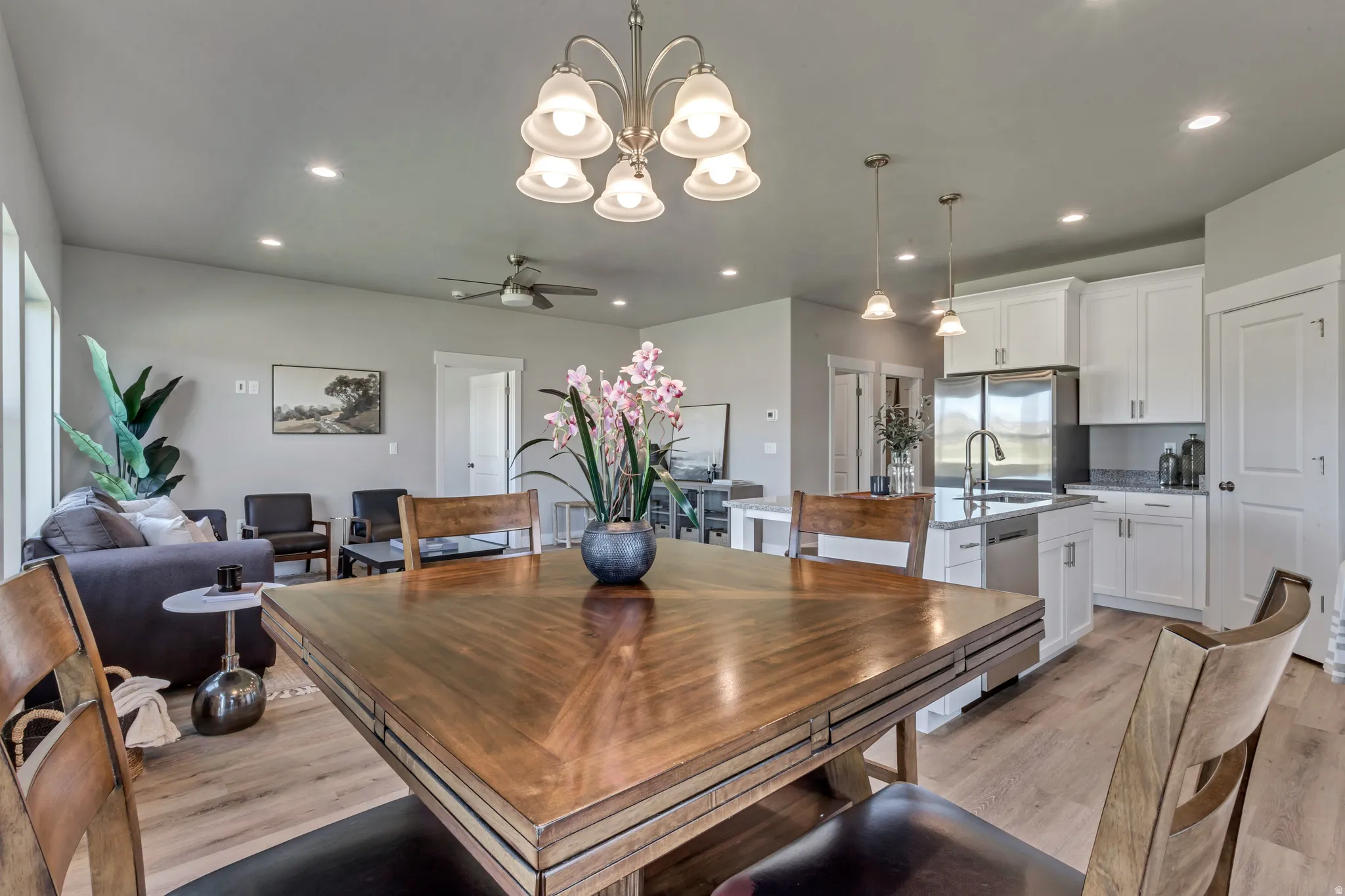 Dining space with ceiling fan, light wood-style floors, recessed lighting, and a chandelier