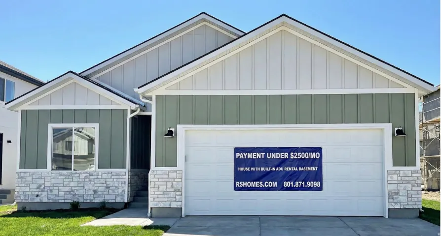 View of front of house with a garage, stone siding, concrete driveway, and board and batten siding