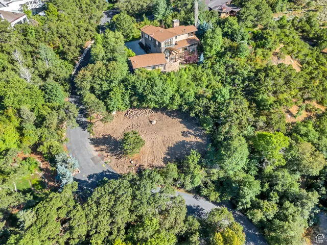 Aerial view of property and surrounding area featuring a forest