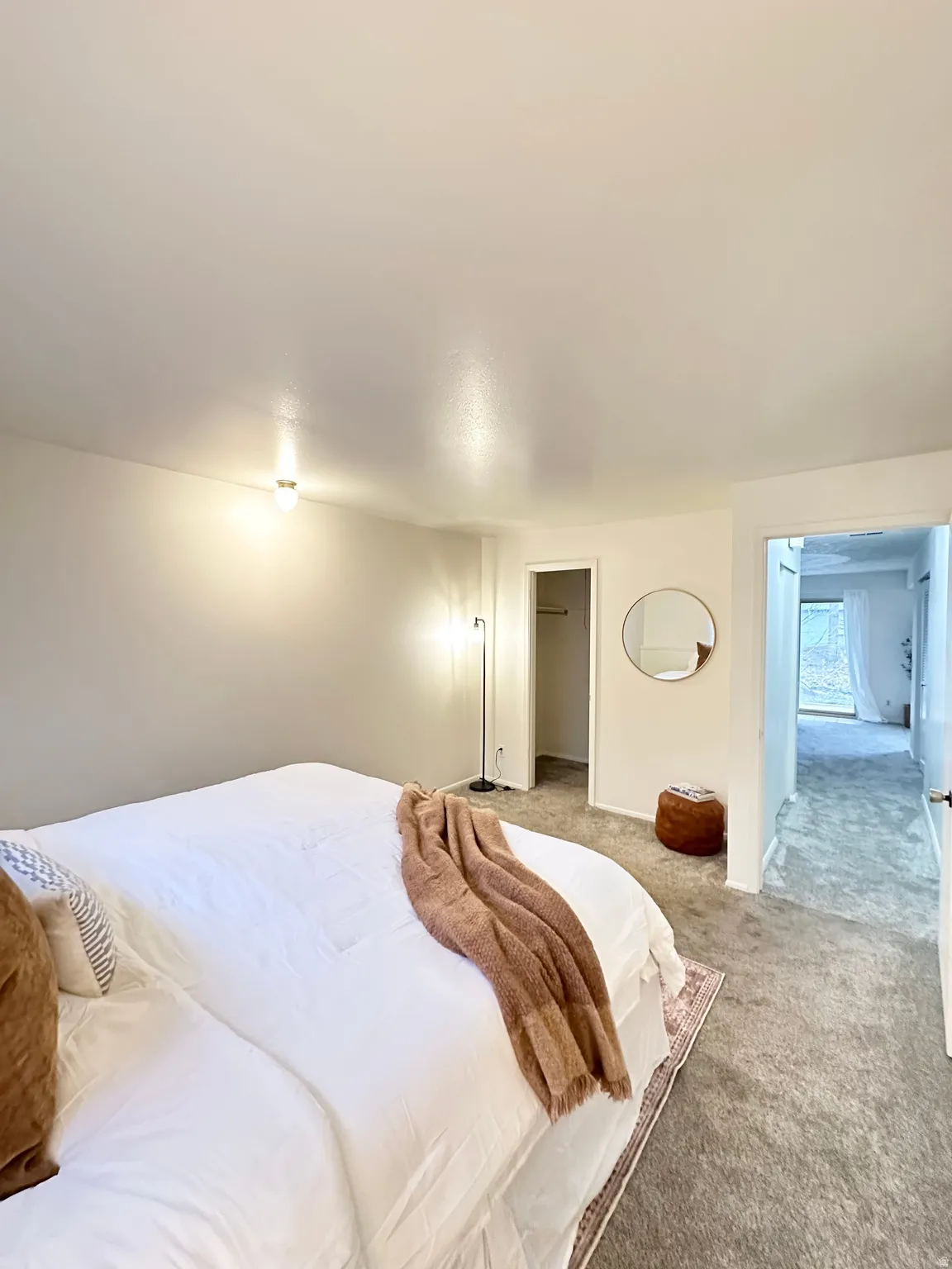 Carpeted bedroom featuring a walk in closet and baseboards