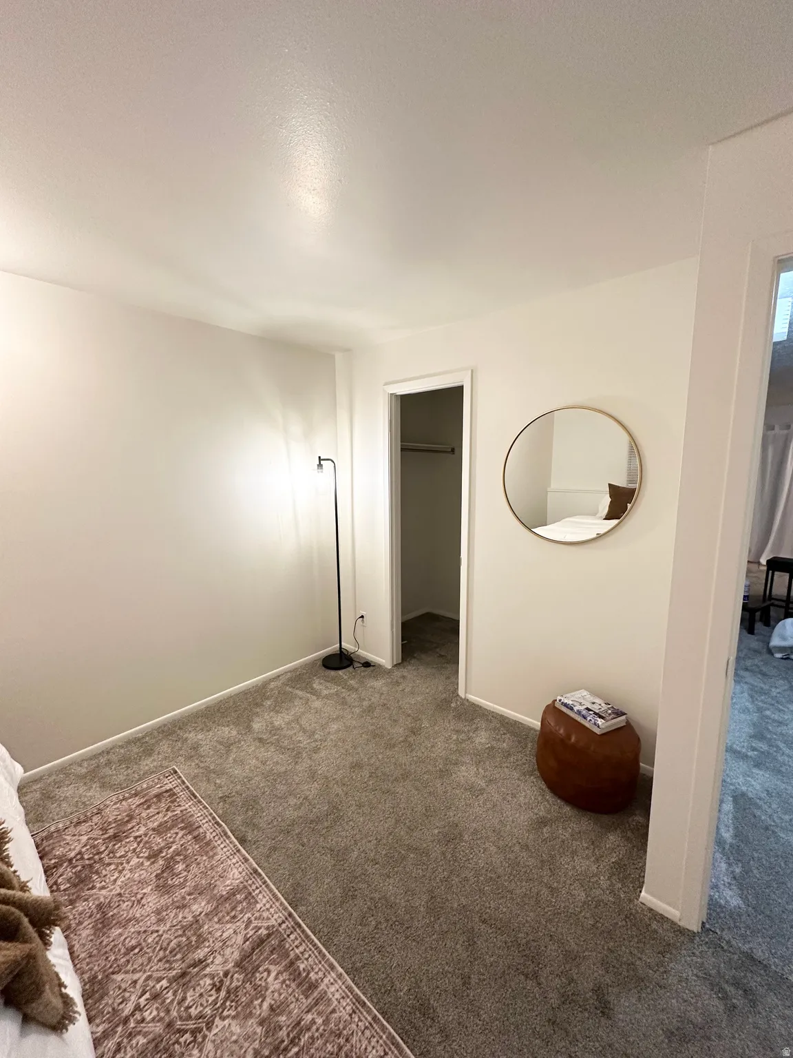 Unfurnished bedroom with a spacious closet and carpet