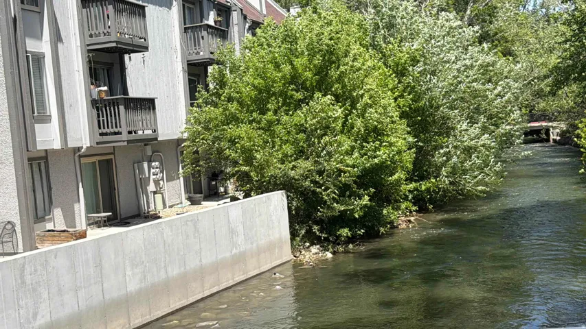 Waterfront property featuring a private patio, sliding glass door access, and multiple balconies with dark wood railings