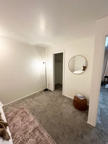 Unfurnished bedroom with a spacious closet and carpet