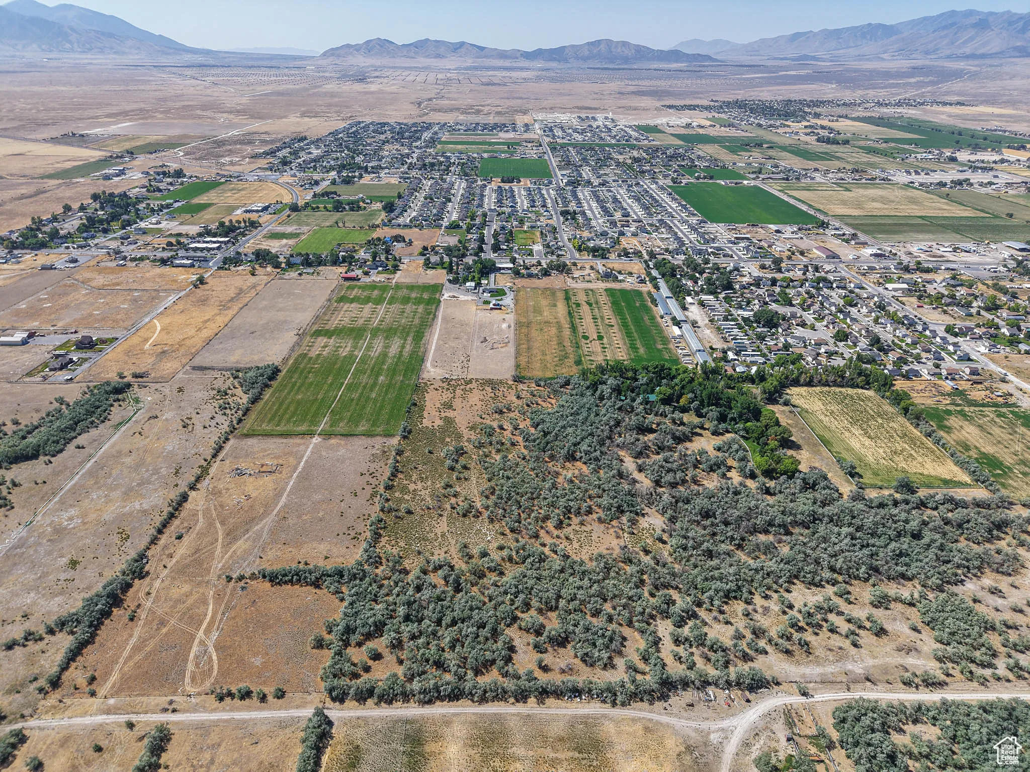 Aerial view of property and surrounding area featuring a mountainous background and rural landscape