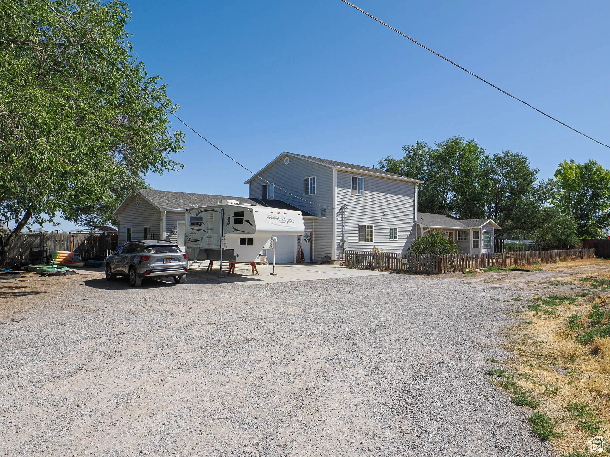 View of front of property featuring gravel driveway