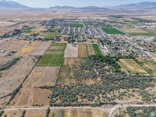 Aerial view of property and surrounding area featuring a mountainous background and rural landscape