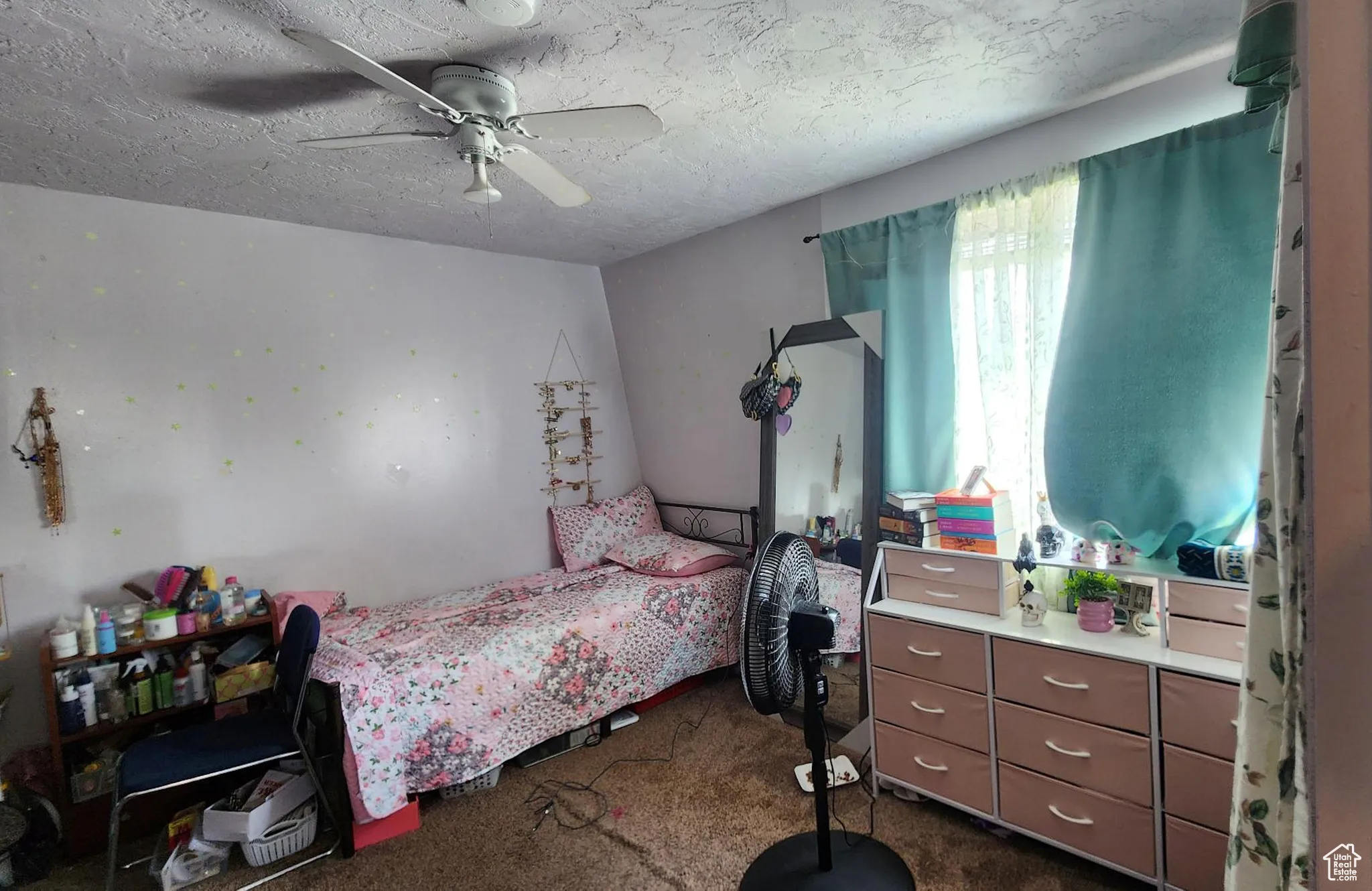 Bedroom featuring dark colored carpet, a textured ceiling, and ceiling fan