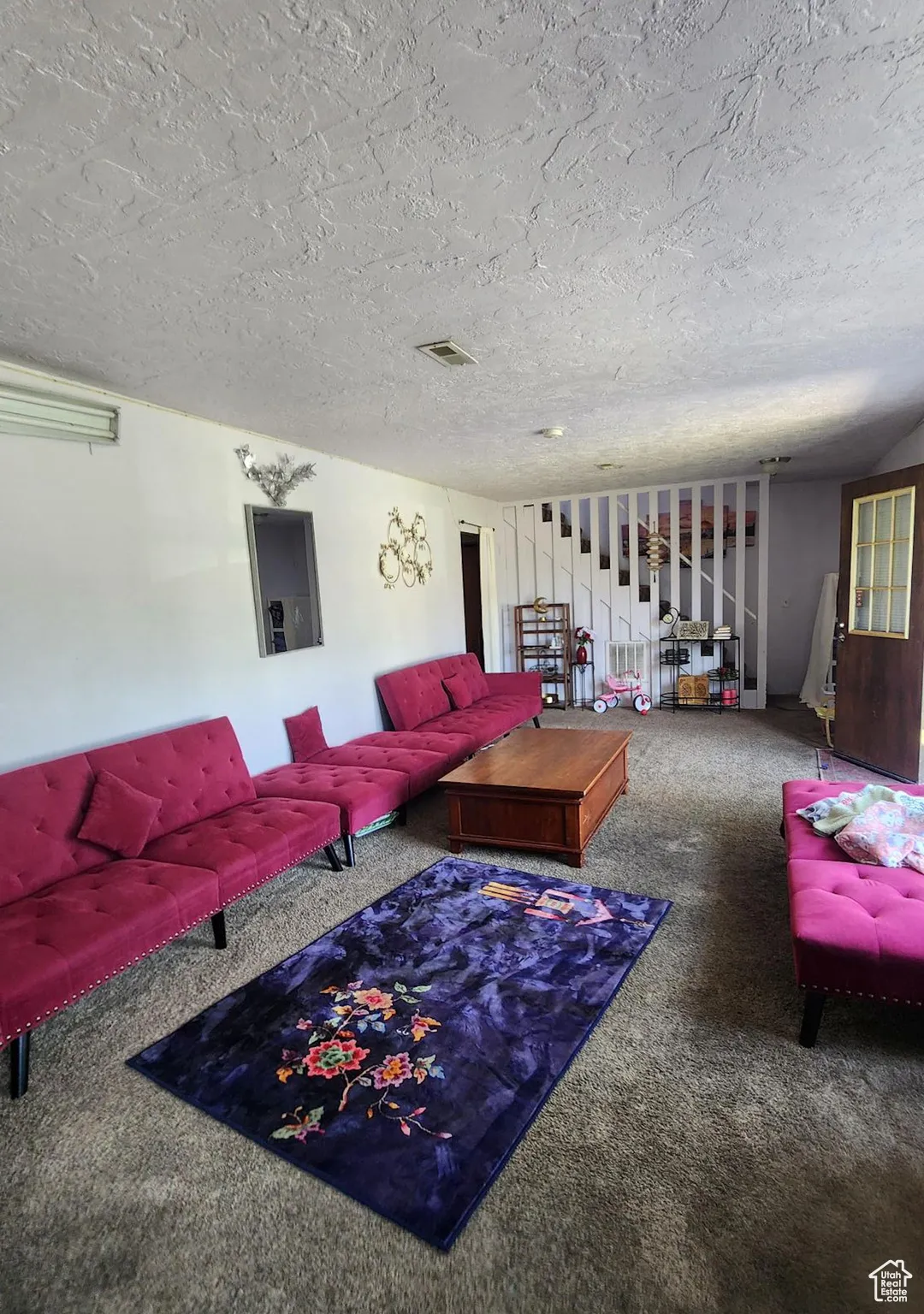 Carpeted living area with a textured ceiling