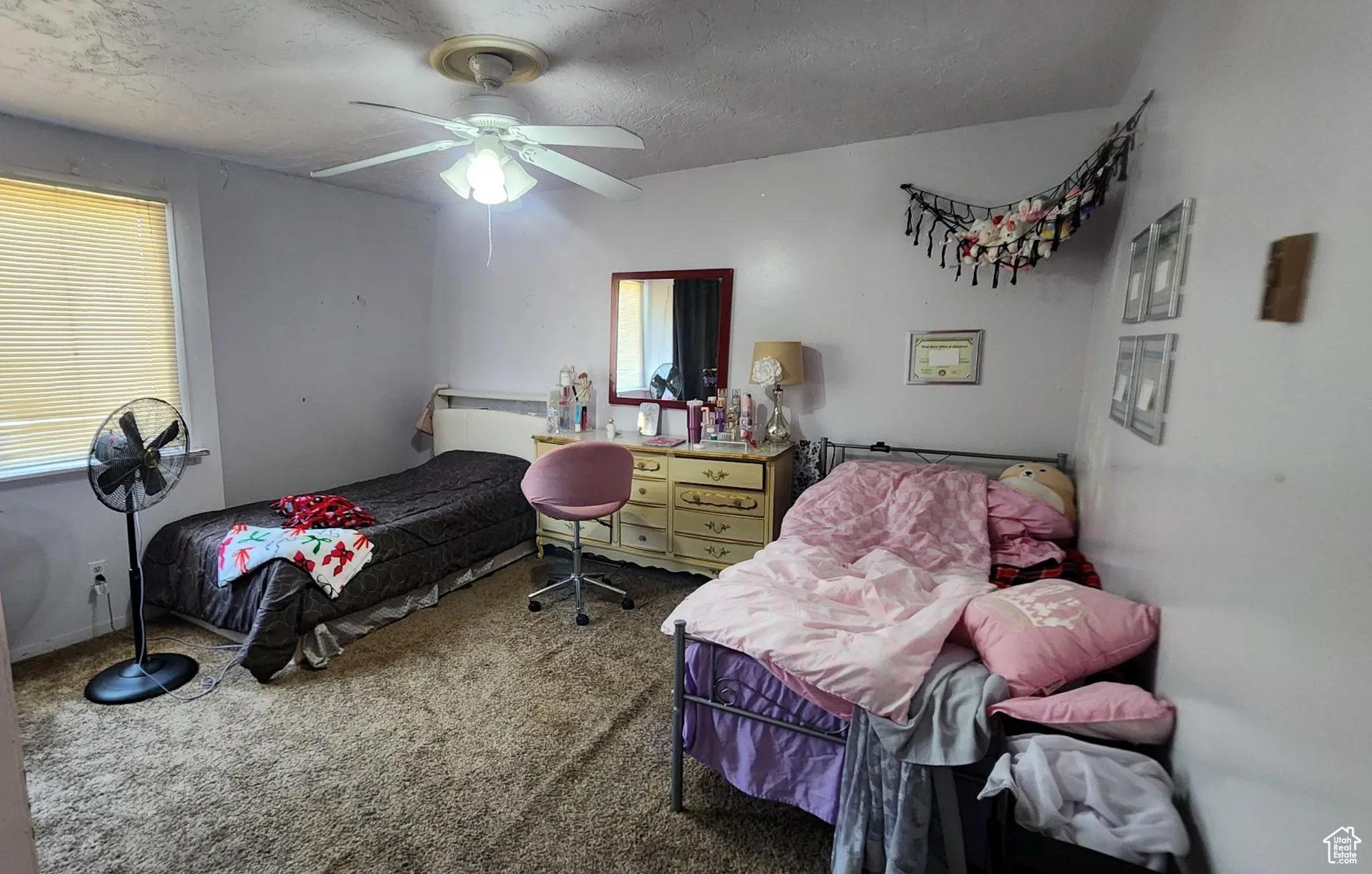 Bedroom featuring carpet floors, a textured ceiling, multiple windows, and a ceiling fan