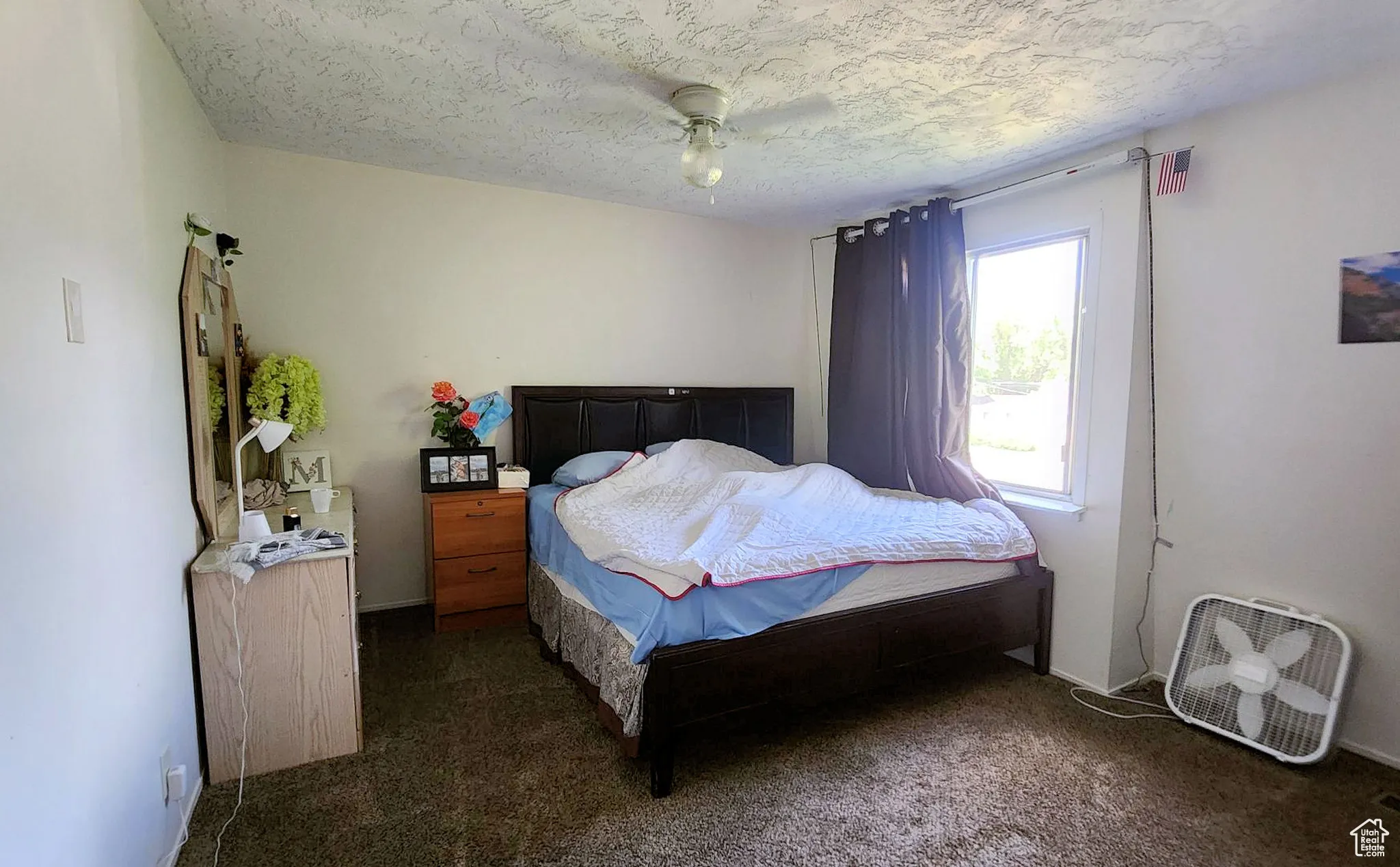 Bedroom with carpet, a textured ceiling, and ceiling fan
