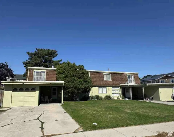 Front of property with driveway, mansard roof, and a front lawn