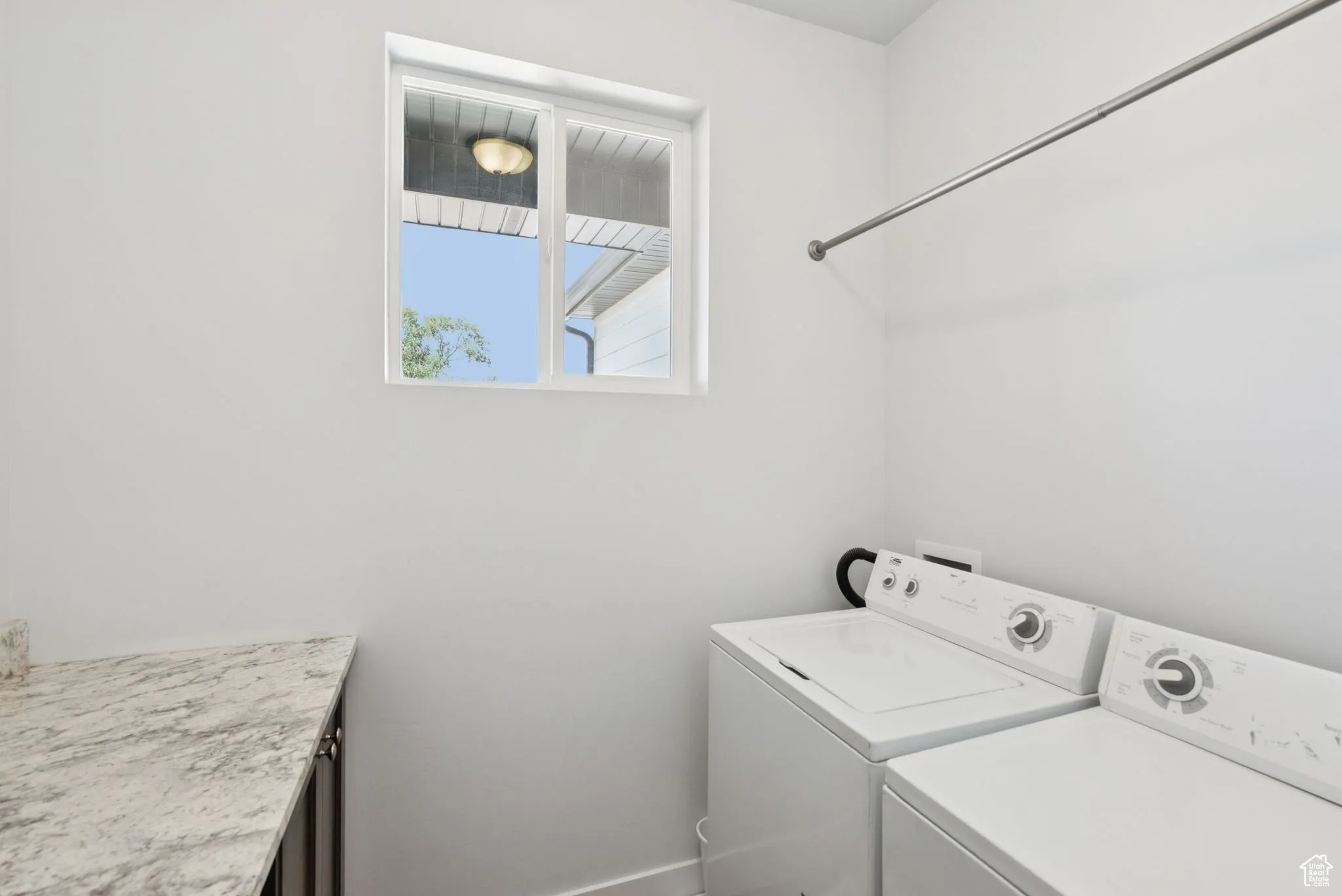 Washroom with washer and dryer and baseboards
