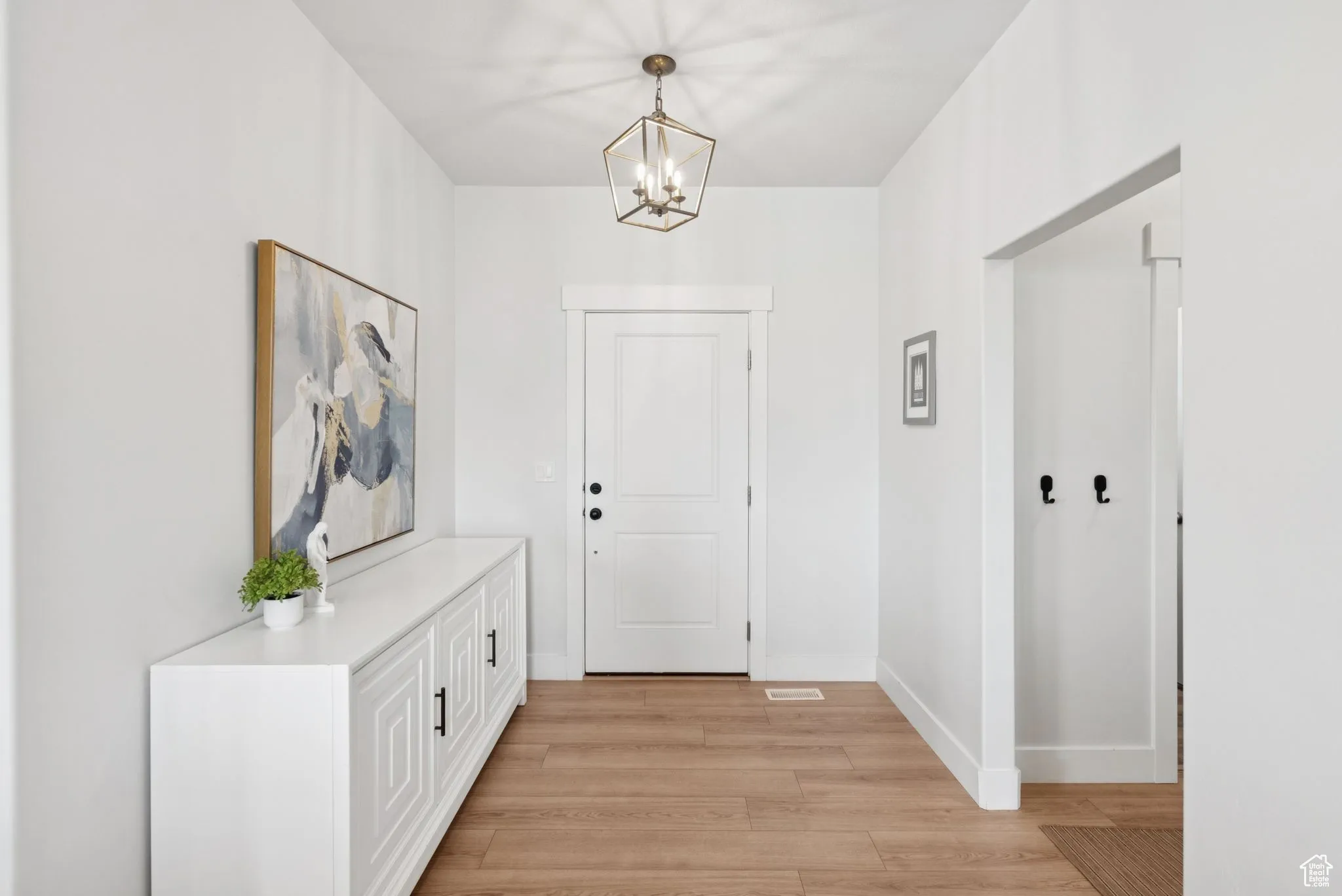 Entrance foyer featuring light wood-style floors and a chandelier