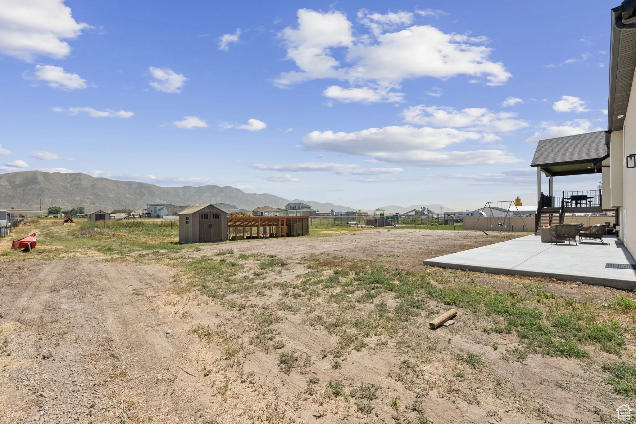 View of yard with a storage unit, a patio area, a residential view, and a mountain view