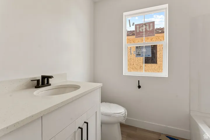 Full bath featuring vanity and dark wood-style flooring