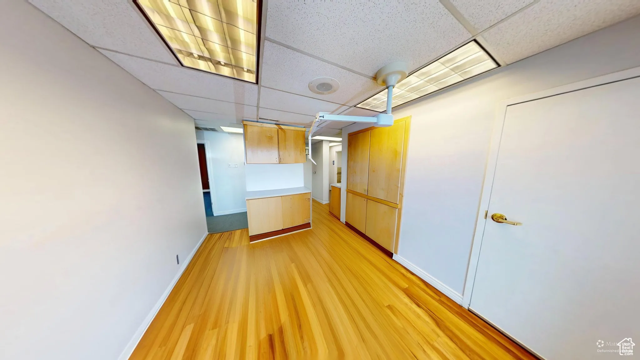 Spare room with a paneled ceiling and light wood finished floors