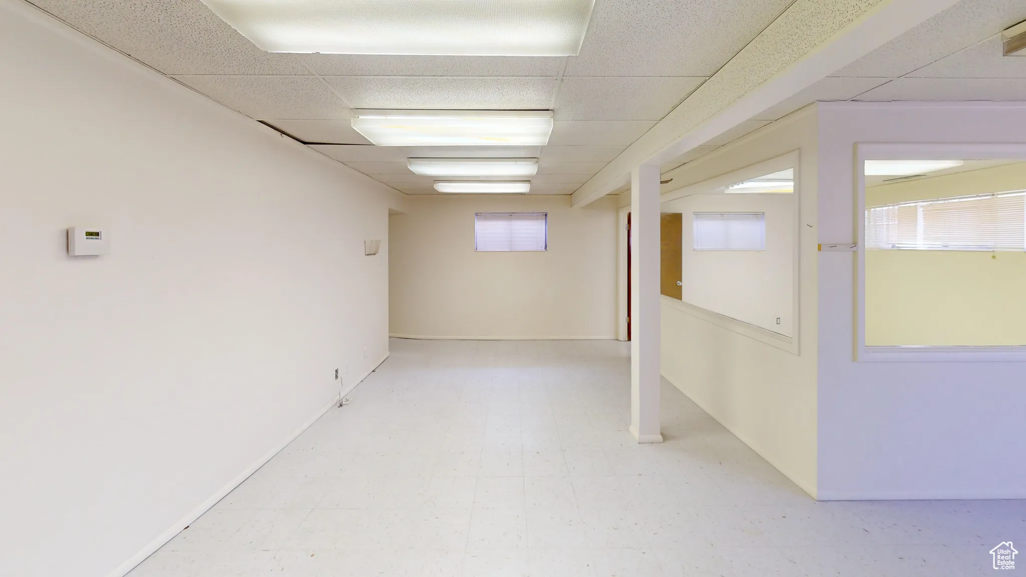 Below grade area featuring light floors and a drop ceiling