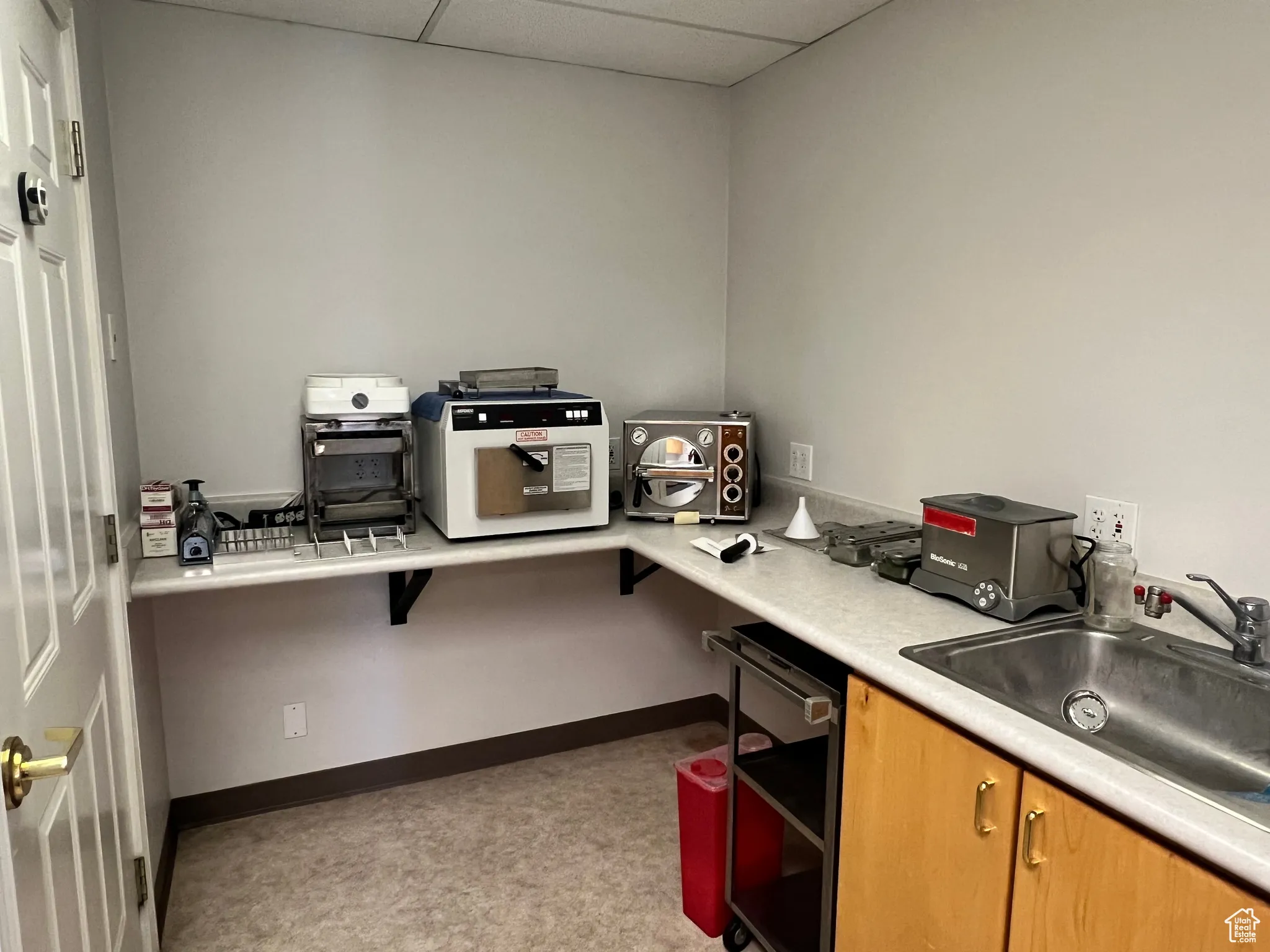 Office space featuring a paneled ceiling and baseboards