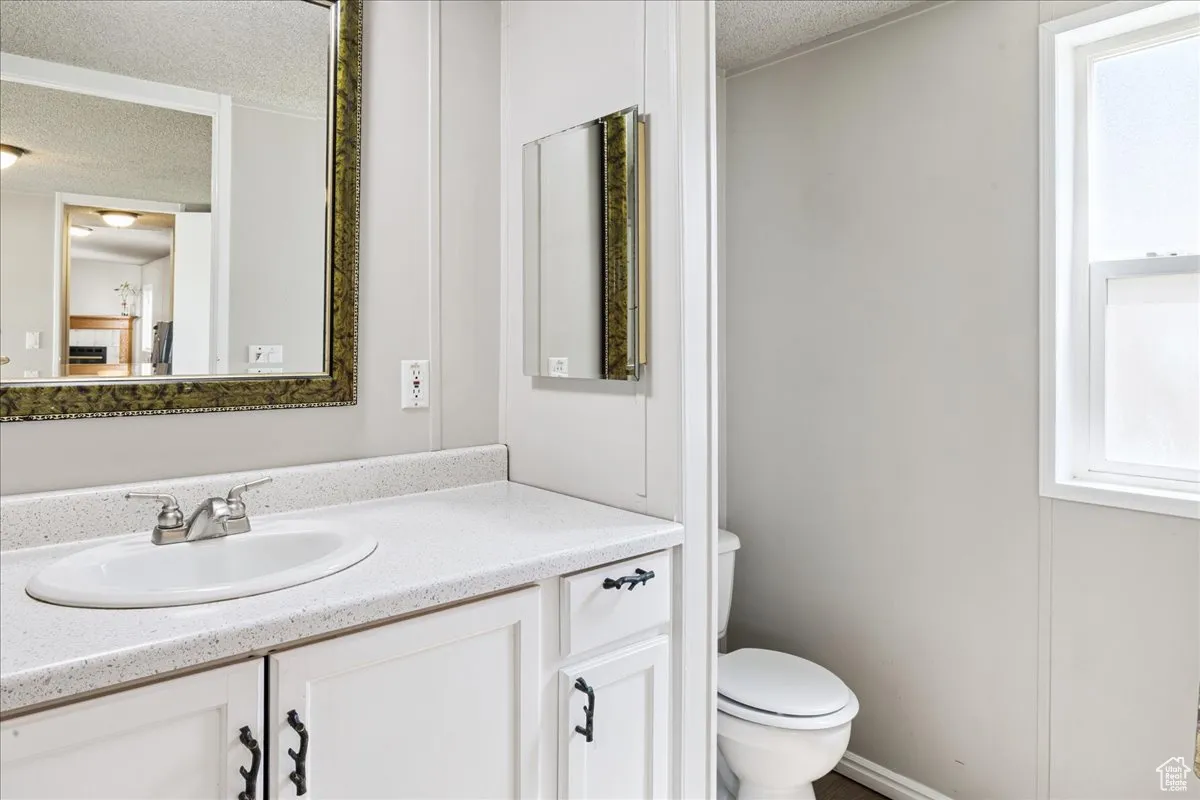 Bathroom with a textured ceiling and vanity