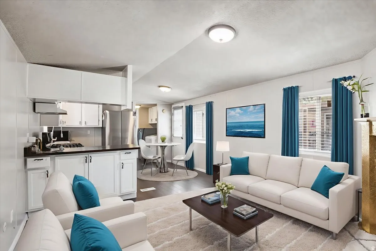 Living area featuring light wood-style floors, healthy amount of natural light, and vaulted ceiling