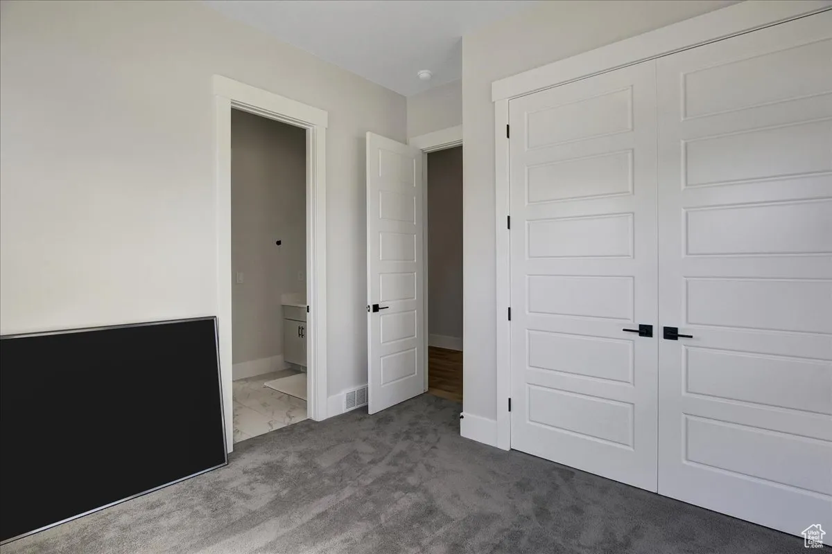 Unfurnished bedroom featuring carpet and a closet
