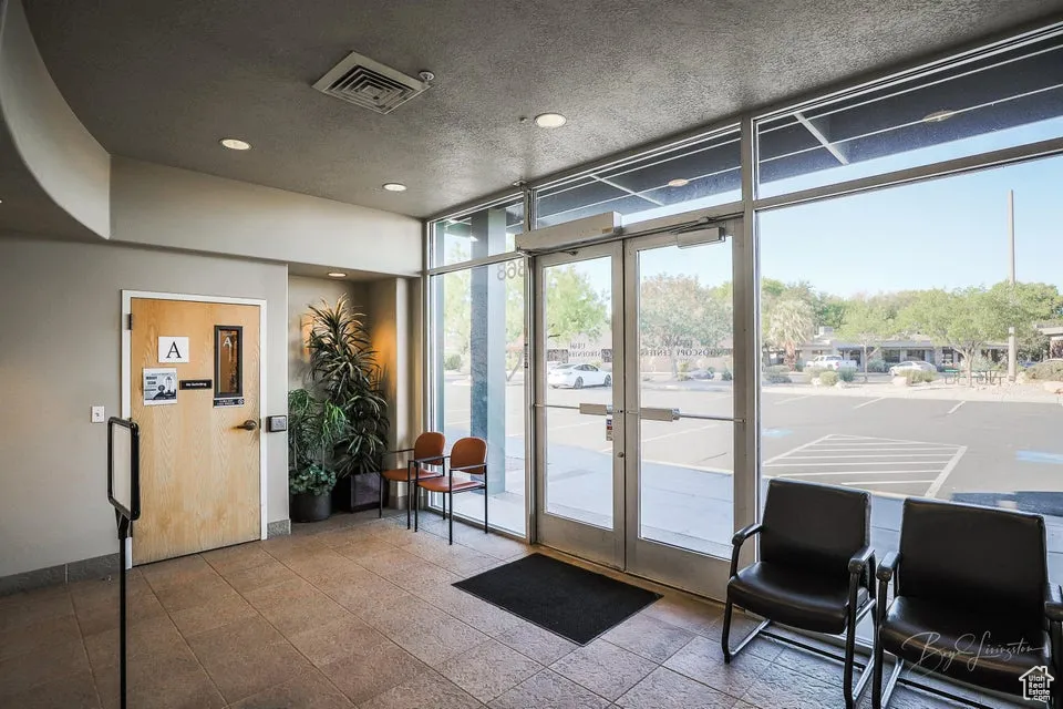 Lobby with a wall of windows, a textured ceiling, and recessed lighting