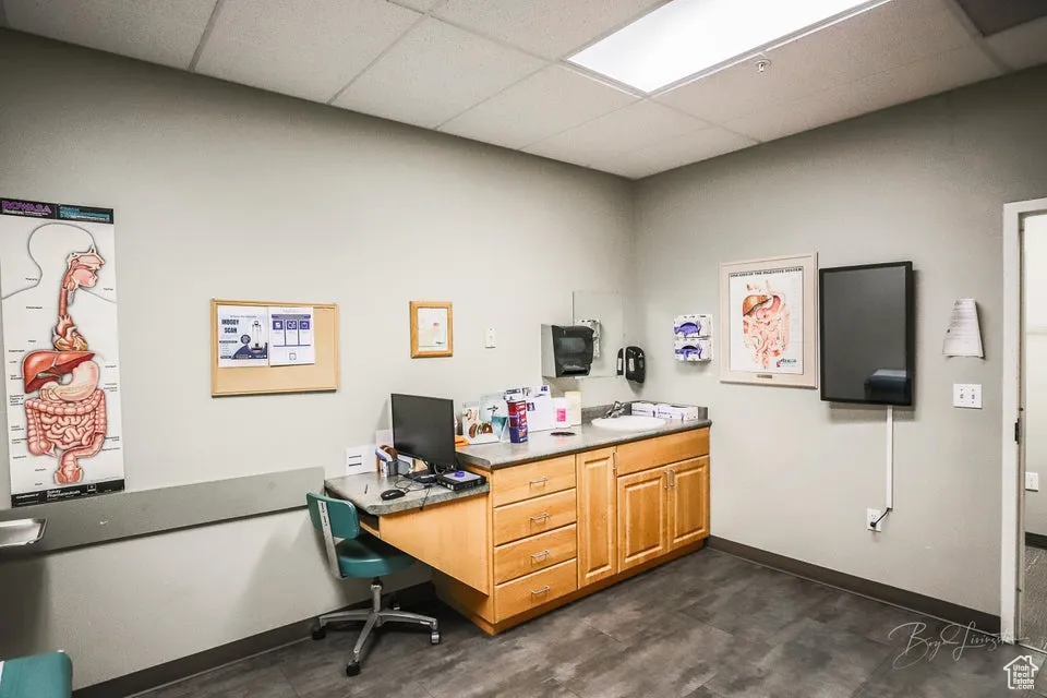 Office space featuring a drop ceiling and baseboards