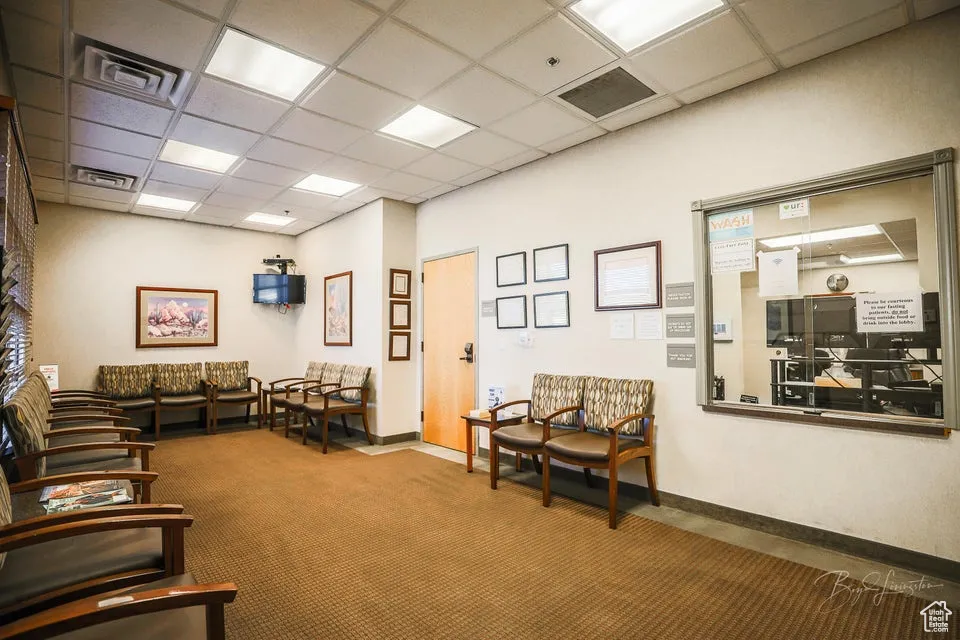 Living room with a drop ceiling and carpet flooring