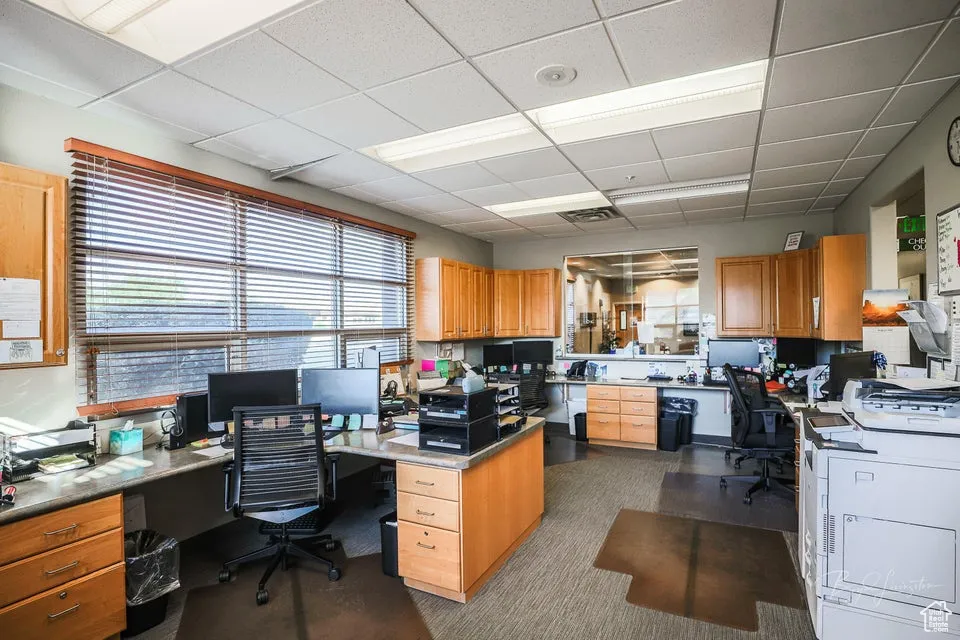 Office area with a drop ceiling and built in desk
