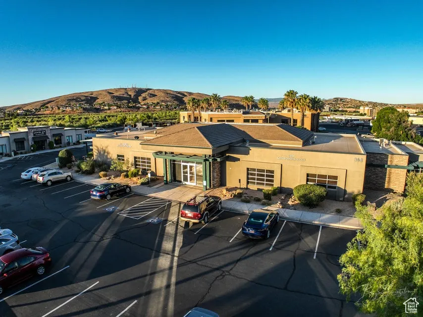 View of property with a mountain view and uncovered parking