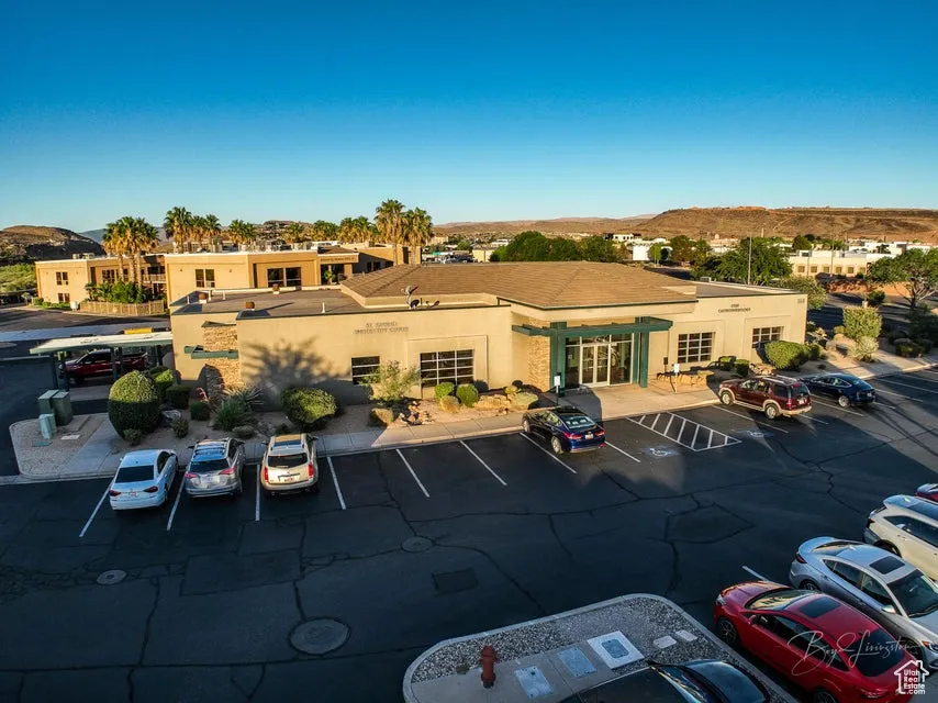 View of property with uncovered parking and a mountain view