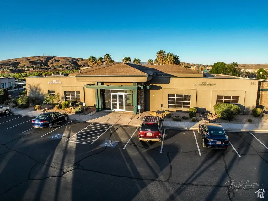 View of building exterior with uncovered parking and a mountain view