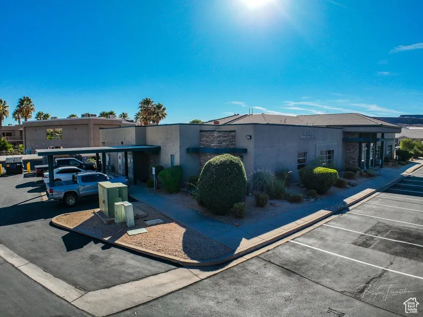 View of front of home with stucco siding and uncovered parking